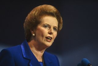 Prime Minster Margaret Thatcher is seen giving her last speech as Prime Minister at the October 1990 Conservative Party Conference in Blackpool, Lancashire before being removed by her own colleagues a few weeks afterwards. Her fighting spirit and stern expression gives her the reputation of Iron Lady with a gaze that make her opponents uncomfortable. She is wearing a favourite two-tone blue suit with wide shoulders and a pearl ear-rings. The ambient stage lights emphasize the blonde highlights in her hair. (Photo by In Pictures Ltd./Corbis via Getty Images)