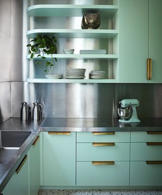 Modern kitchen with teal cabinets and stainless steel worktops