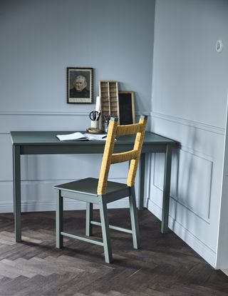 desk area with painted dark/teal blue desk and chair with yellow twine wrapped around by ikea
