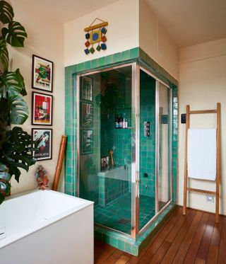 green tiled shower room with bath and plant