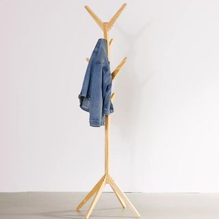 A wooden coat rack with a denim jacket on it