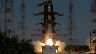 a red and white indian rocket launches into a grayish-blue sky.