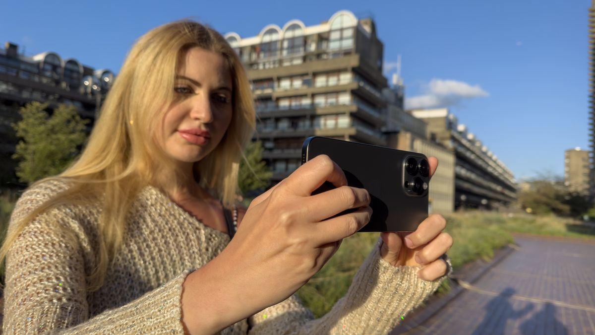 Woman holding an iPhone 15 Pro Max phone