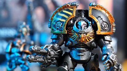 A Saturnine Terminator in Iron Warriors colors takes aim, while soldiers can be seen in the background