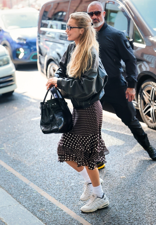 Bella Hadid wears a polka dot skirt with nike sneakers in london