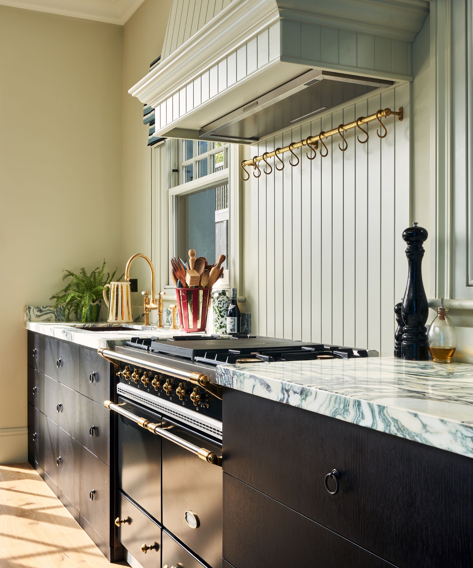 A small kitchen with warm neutral walls, a paneled backsplash, and black-stained wooden cabinets