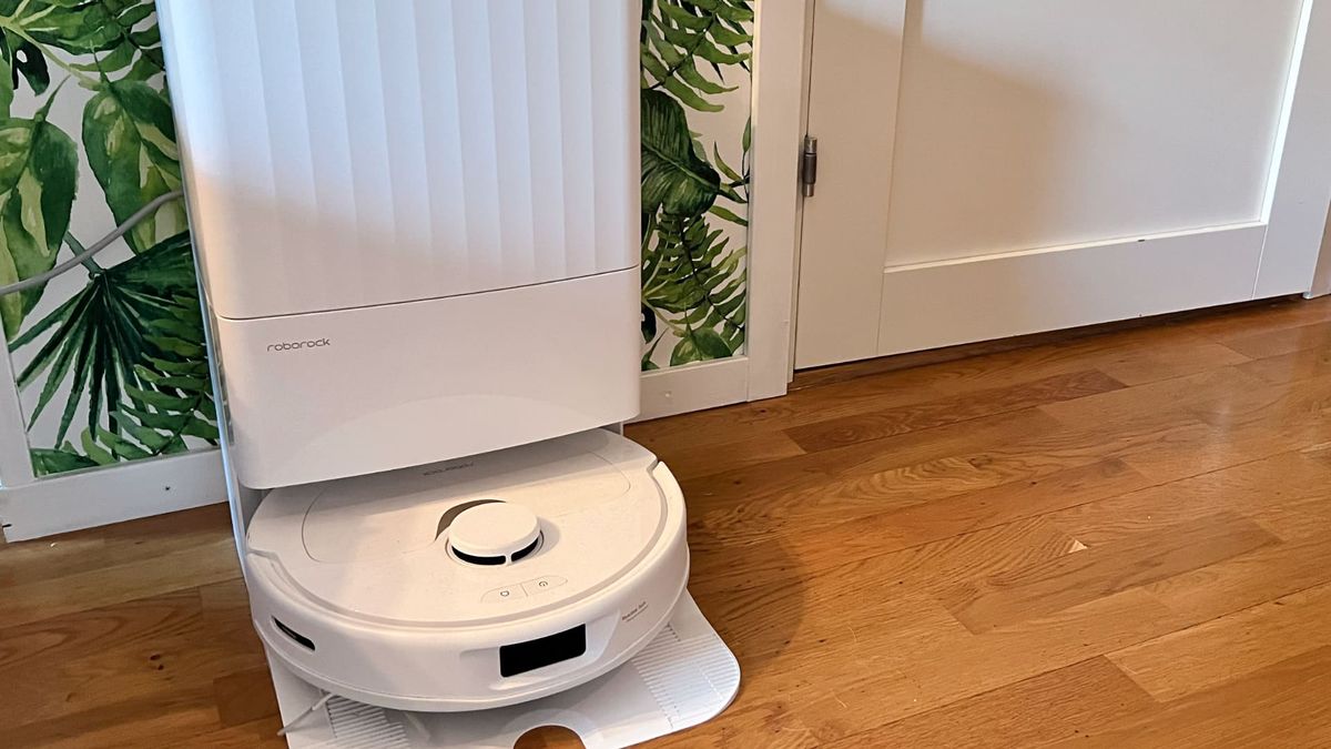 Roborock Q Revo med dockningsstation mot gr&ouml;n tapet