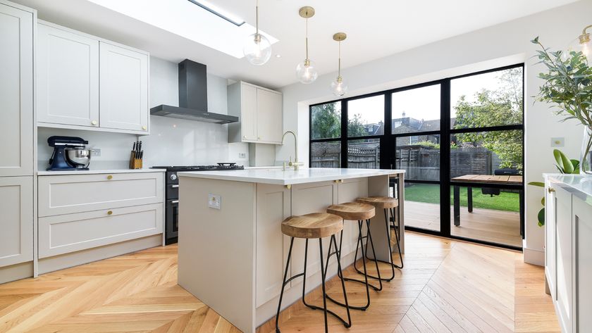 kitchen extension with off white wooden units, wooden floor, black cooker hood, large skylight and large black framed patio doors