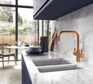 A modern kitchen with marble effect backplash and copper faucet decor