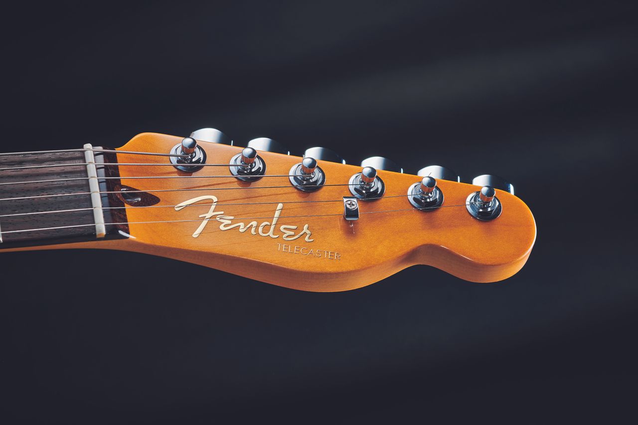 The raised metallic logo changes from chrome to gold here. The maple necks are lightly toned, too. As with the Elites, bone nuts are standard. Note the truss rod adjustment behind the bone nut rather than the modern rotary adjustment at the base of the neck like the Elite Tele