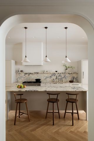 A kitchen island with pendant lights above it