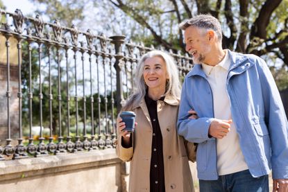 A mature couple go for a walk in a city.