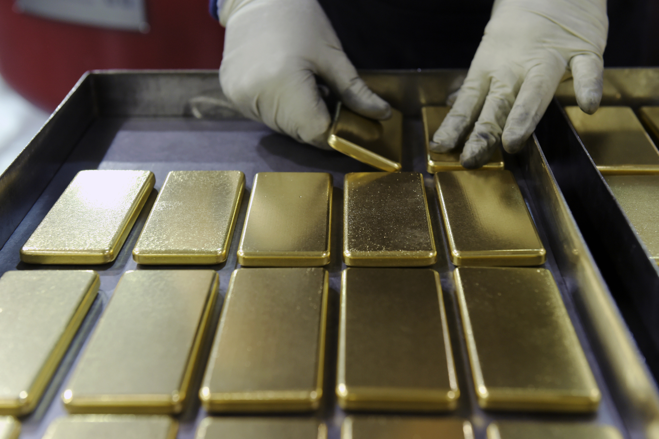 An employee arranges one kilogram gold bars