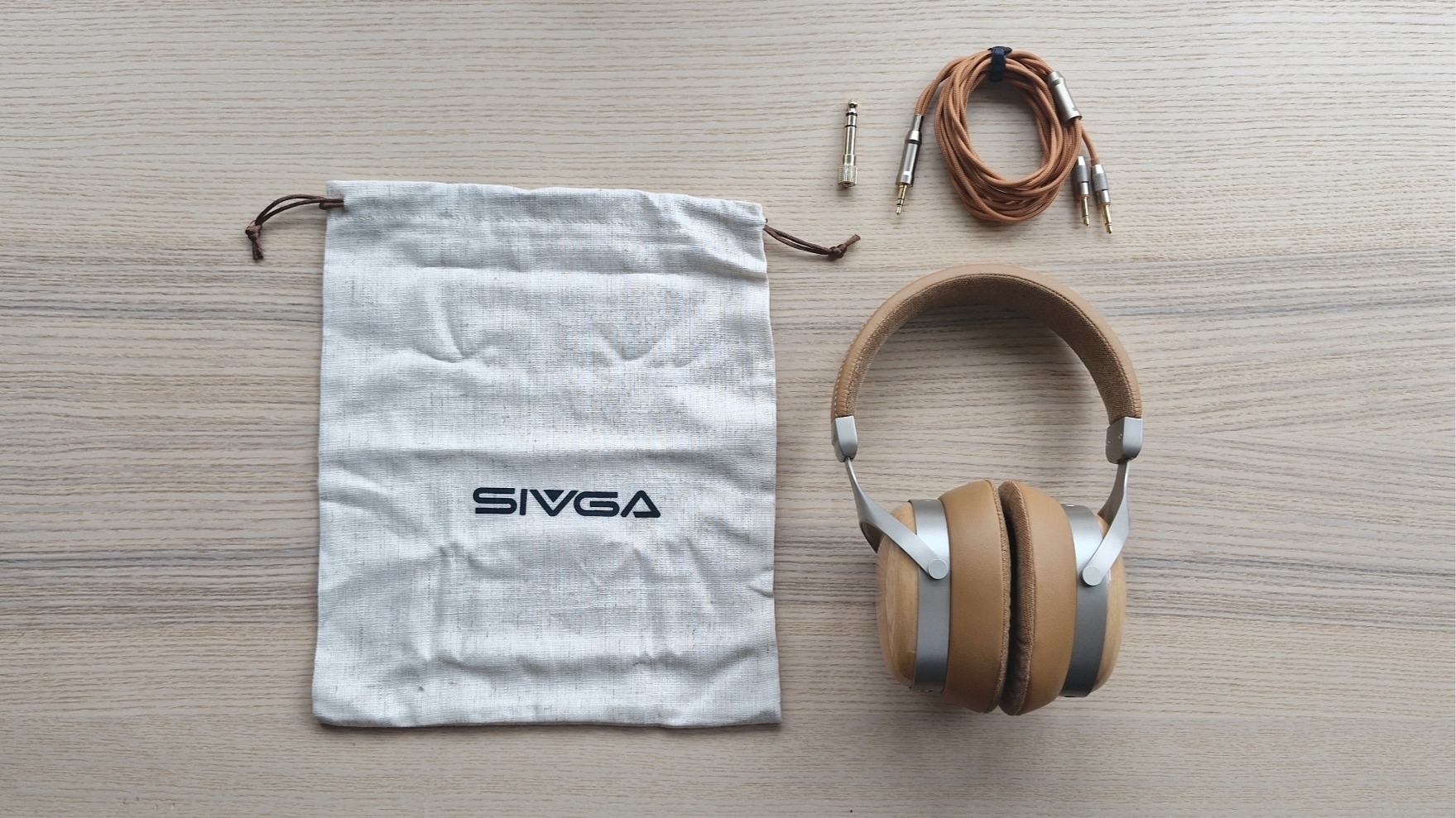 Sivga Robin SV021 Pro over-ear wired headphones laid out on wooden surface, with carry bag.