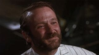 A close up of Robin Williams with a beard, smiling.