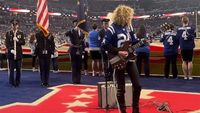 Grace Bowers playing guitar in a football stadium