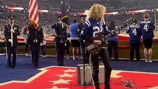 Grace Bowers playing guitar in a football stadium