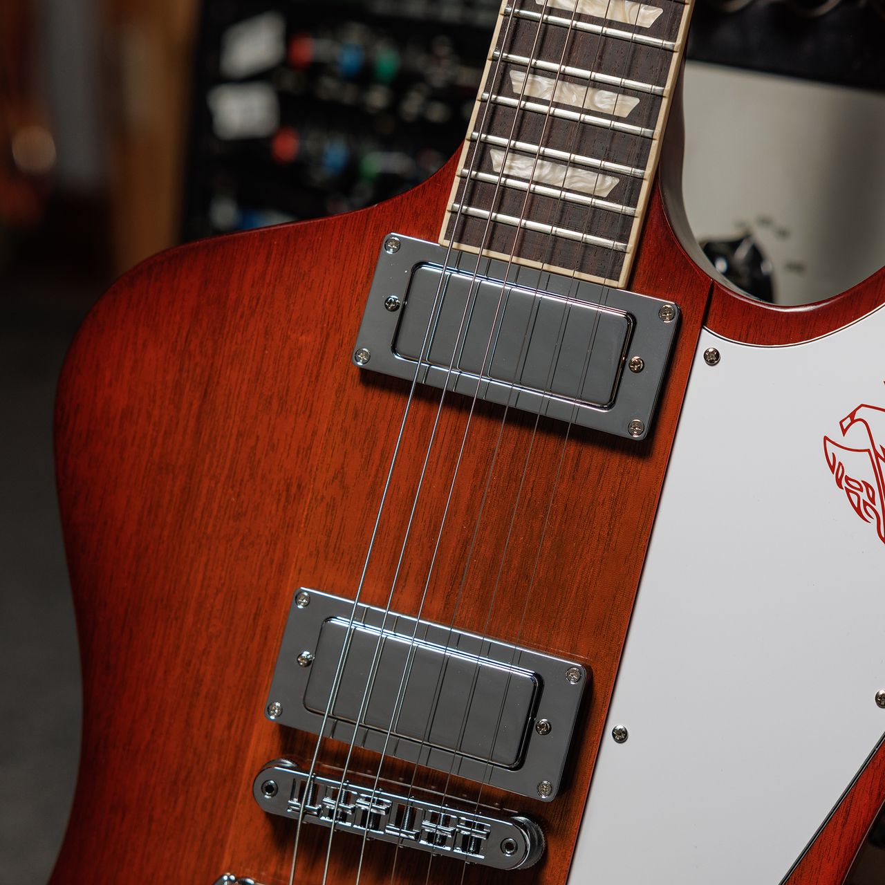 A photo showing a detail of the Gibson Firebird Platypus guitar in a recording studio setting