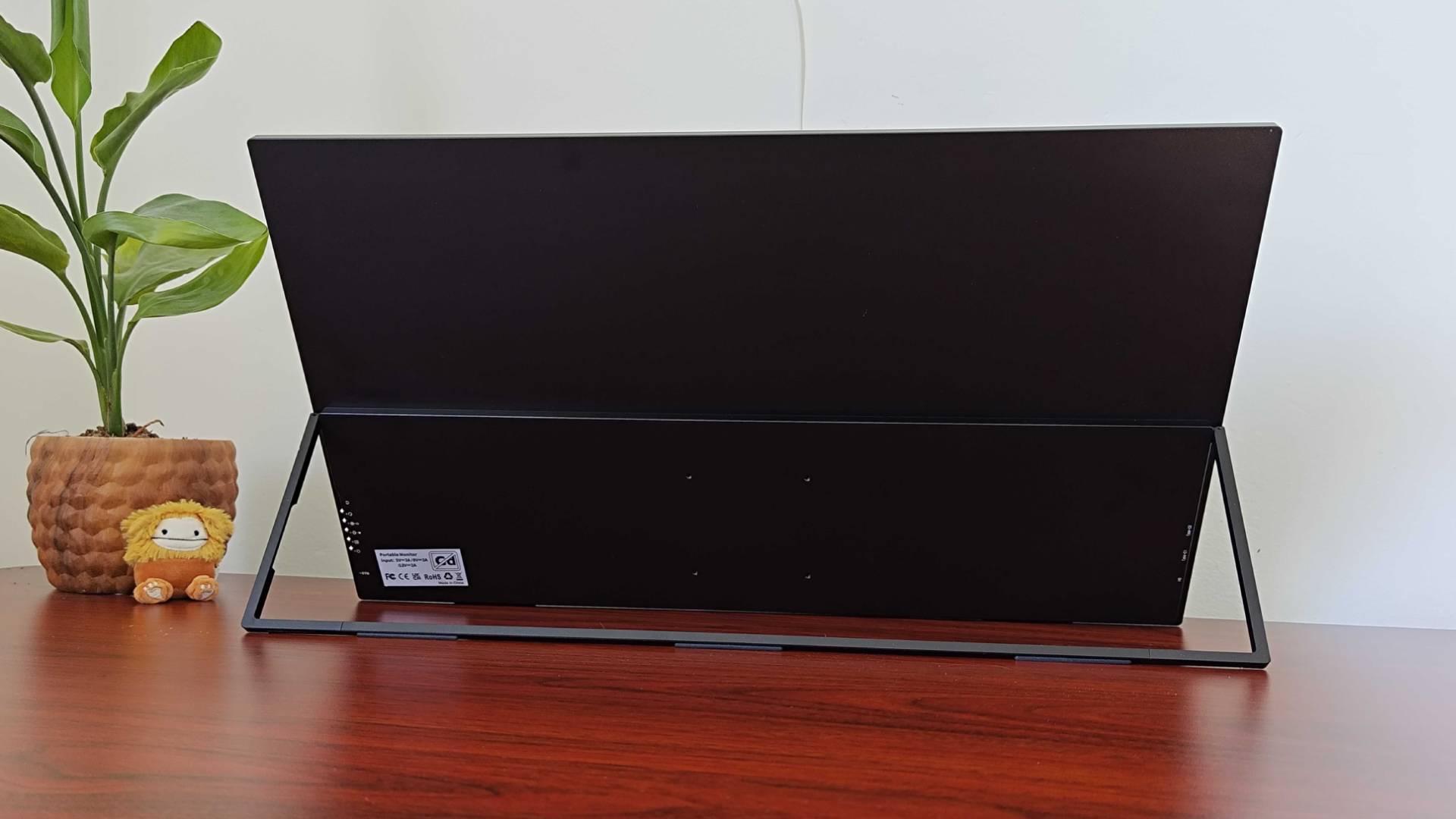 Back view of Uperfect Umax 24 portable monitor on desk with the kickstand flipped out.