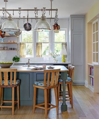 Kitchen island in foreground with pots and pans over the top