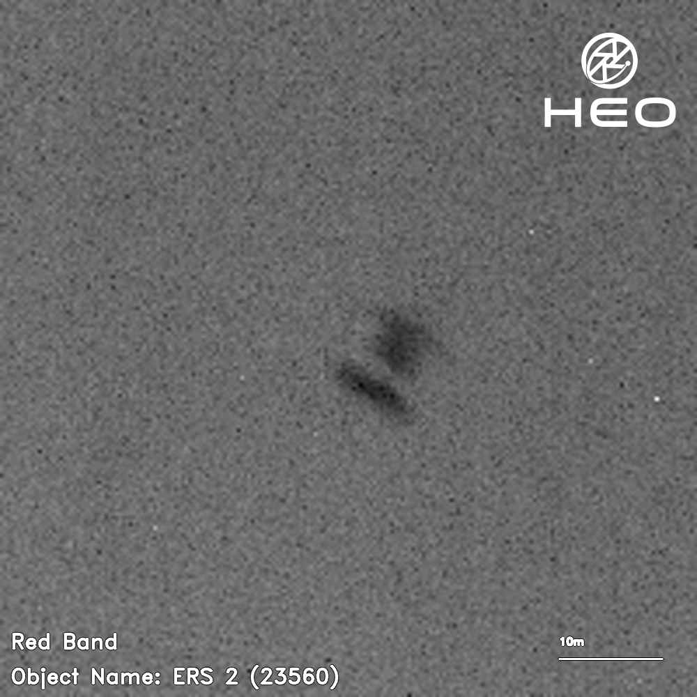 a blurry black-and-white image of an H-shaped satellite against a background of a few dozen stars