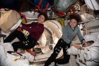 NASA astronauts Christina Koch (left) and Jessica Meir prepare their spacesuits for a series of spacewalks in January 2020.