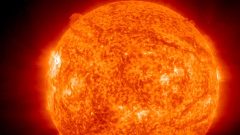 Animação GIF mostrando o flare solar da classe de classe em erupção do membro superior esquerdo do sol.