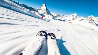 A pair of skis heading down hill in the Alps