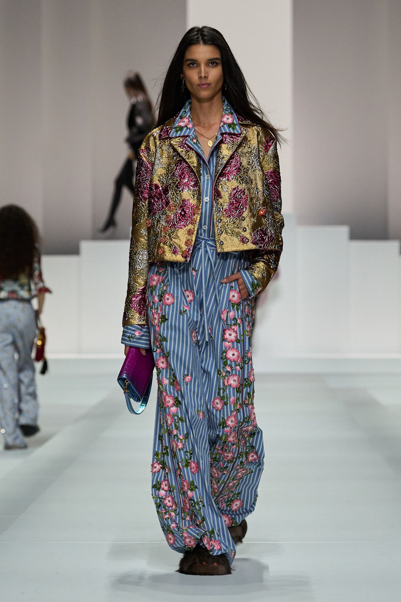 A model on dolce & Gabbana runway wears a pajama-inspired outfit with flroals.