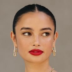 Kelsey Merritt in a low bun, with red lip, smokey eye and gold jewellery at the Spring 2024 New York Fashion Week Runway shows - best mascara