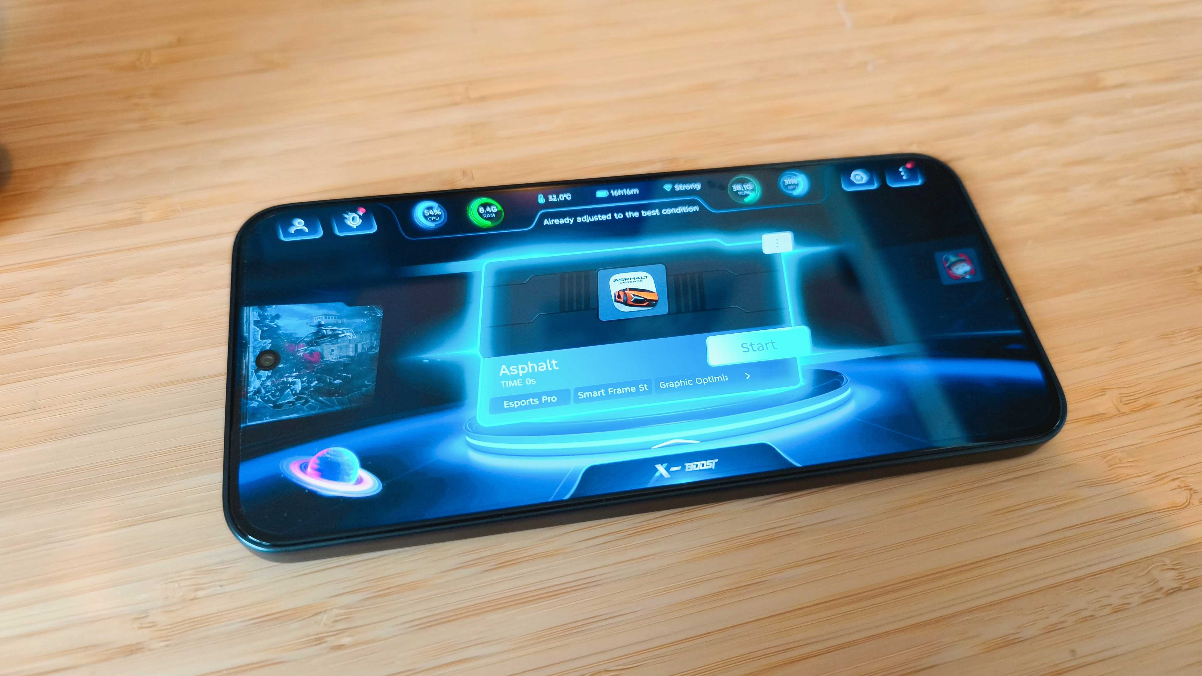 A black Infinix GT 30 Pro phone on a wooden desk