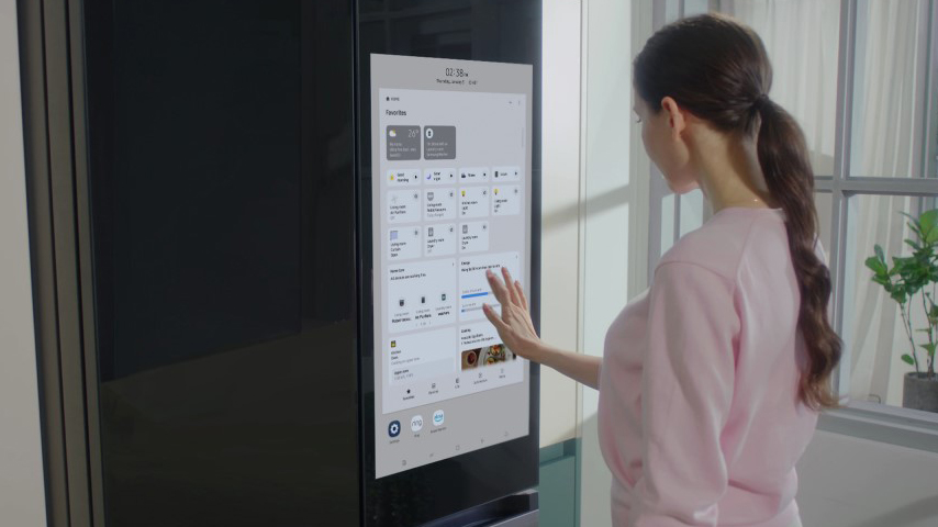 A woman operating the screen of the Samsung Bespoke 4-Door Flex refrigerator