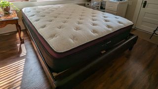 Our Helix Dusk Luxe testing model is placed on a wooden bedframe at our reviewer's house