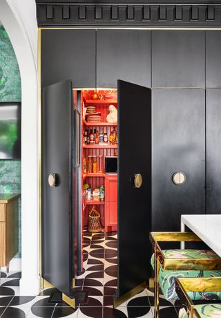 a black kitchen with a hidden red pantry