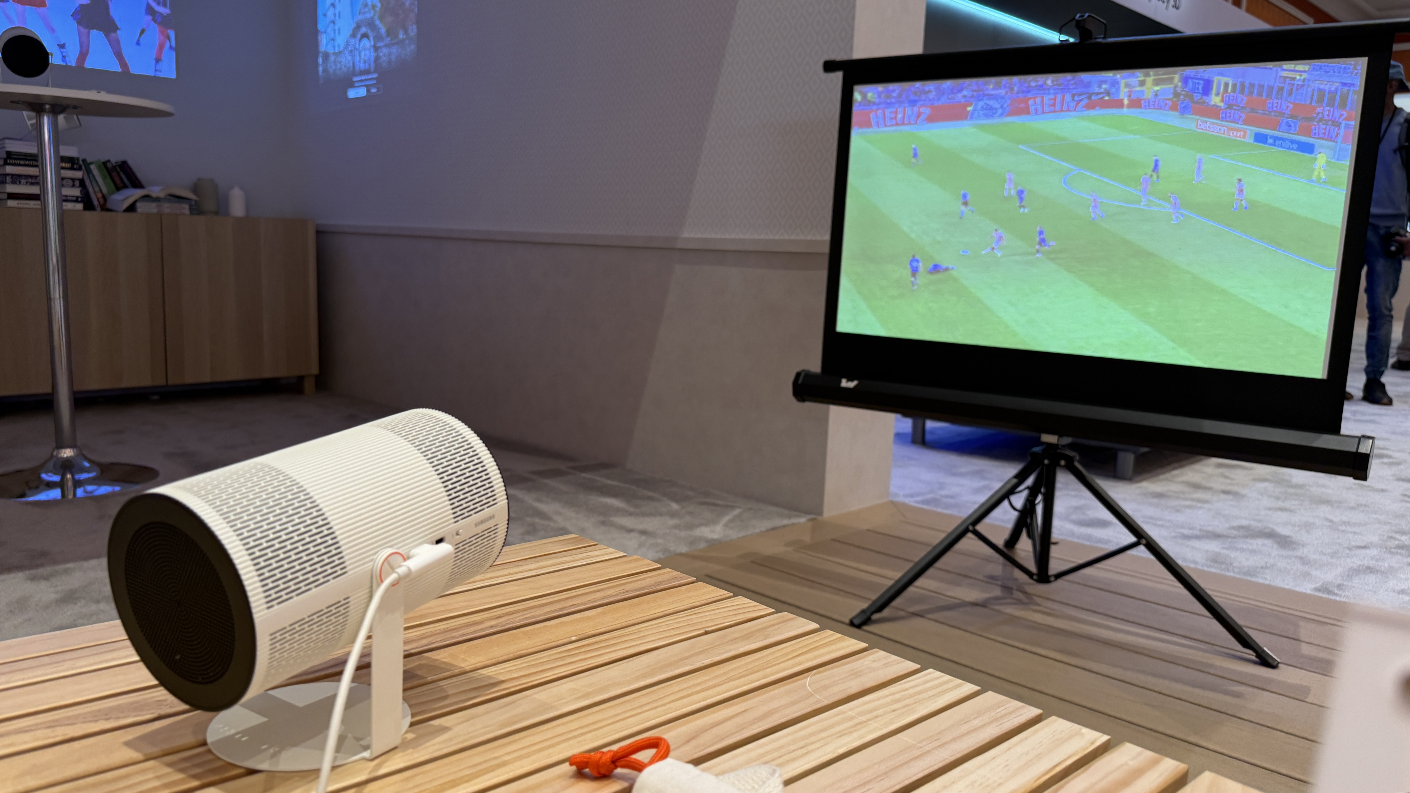 The Samsung FreeStyle+ projector showing a football match on a portable projector screen
