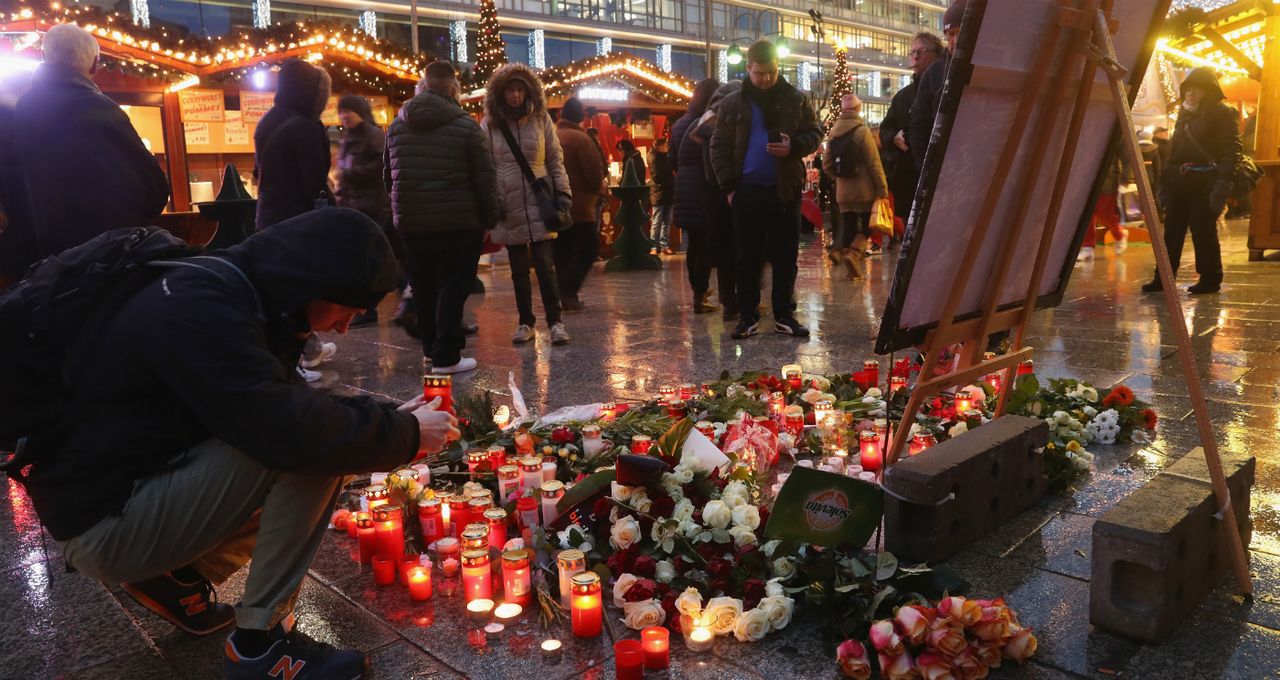 A visitor lays a candle at a makeshift memorial inside the reopened Breitscheidplatz Christmas market in 2016.