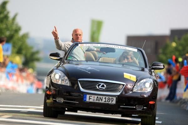 Former professional cyclist Rudi Altig counts down the remaining laps.