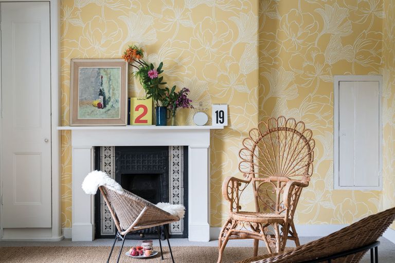 light yellow wallpaper with fine line drawn white floral patterns throughout in a living room space with wooden furniture 