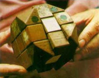 early prototype wooden Rubik's Cube held in hands