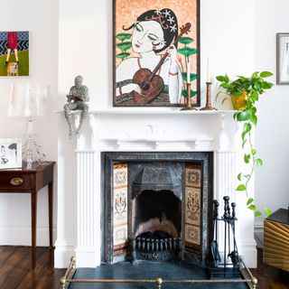 white fireplace with houseplant and artwork