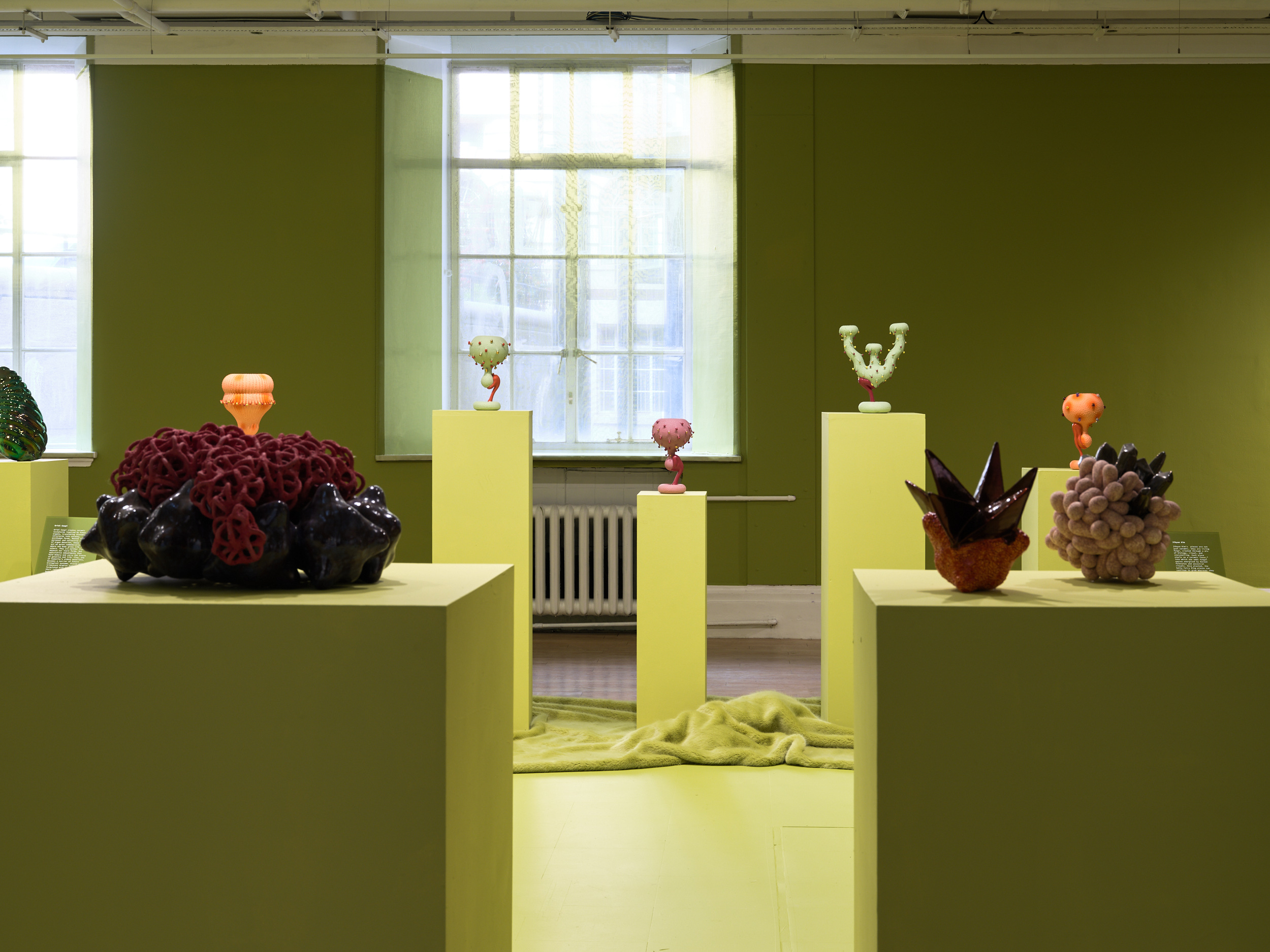Futuristic ceramics in green gallery space