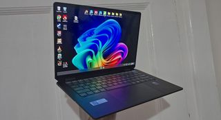 The HP OmniBook Ultra Flip laptop switched on and being held up