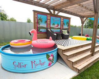 colorful painted stock tank pool next to a covered deck