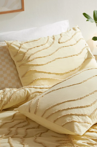 creamy yellow duvet and pillow with a raised line design in a tufted texture