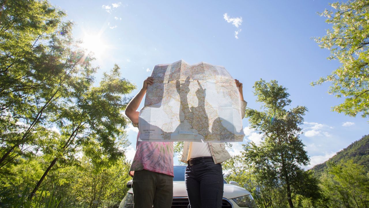 Straight couple in the woods looking at a map