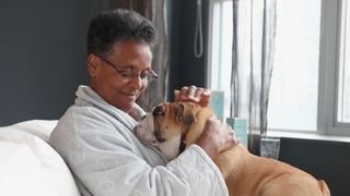 Senior lady cuddles an English bulldog, one of the best dogs for seniors