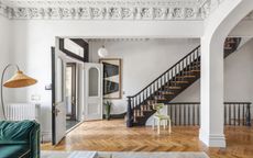 open plan living room and entryway with staircase in wood and black rail and spindles