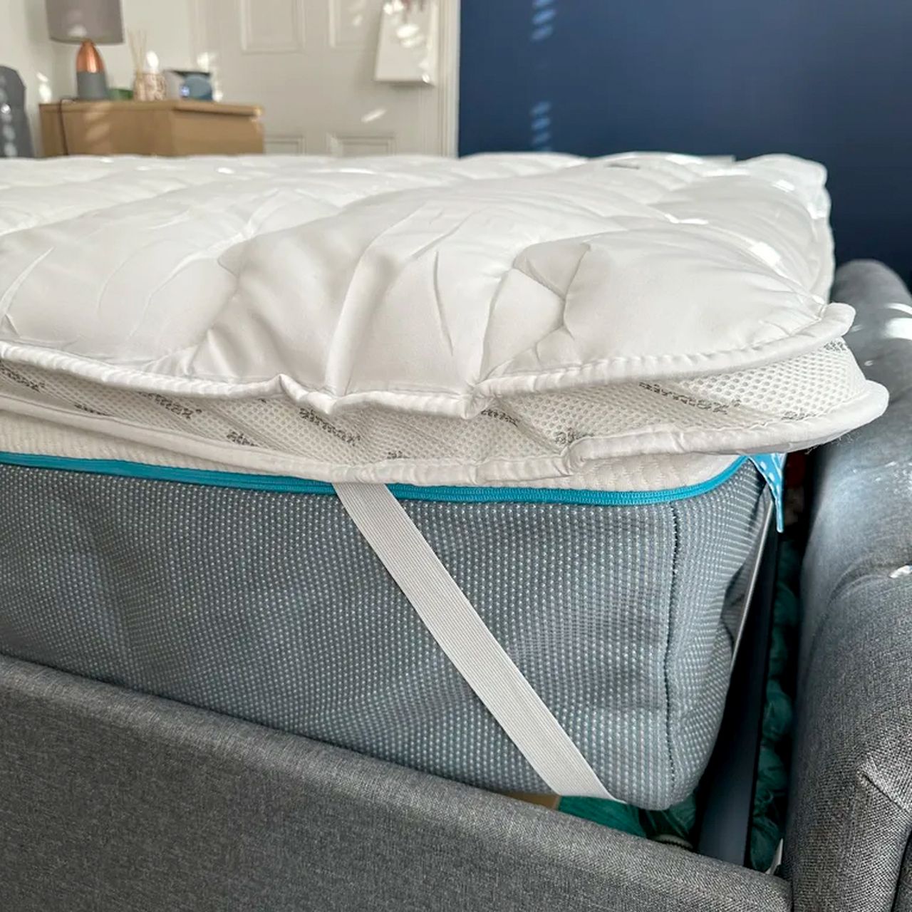 One corner of the Silentnight Airmax mattress topper attached to a mattress via its elasticated corner straps