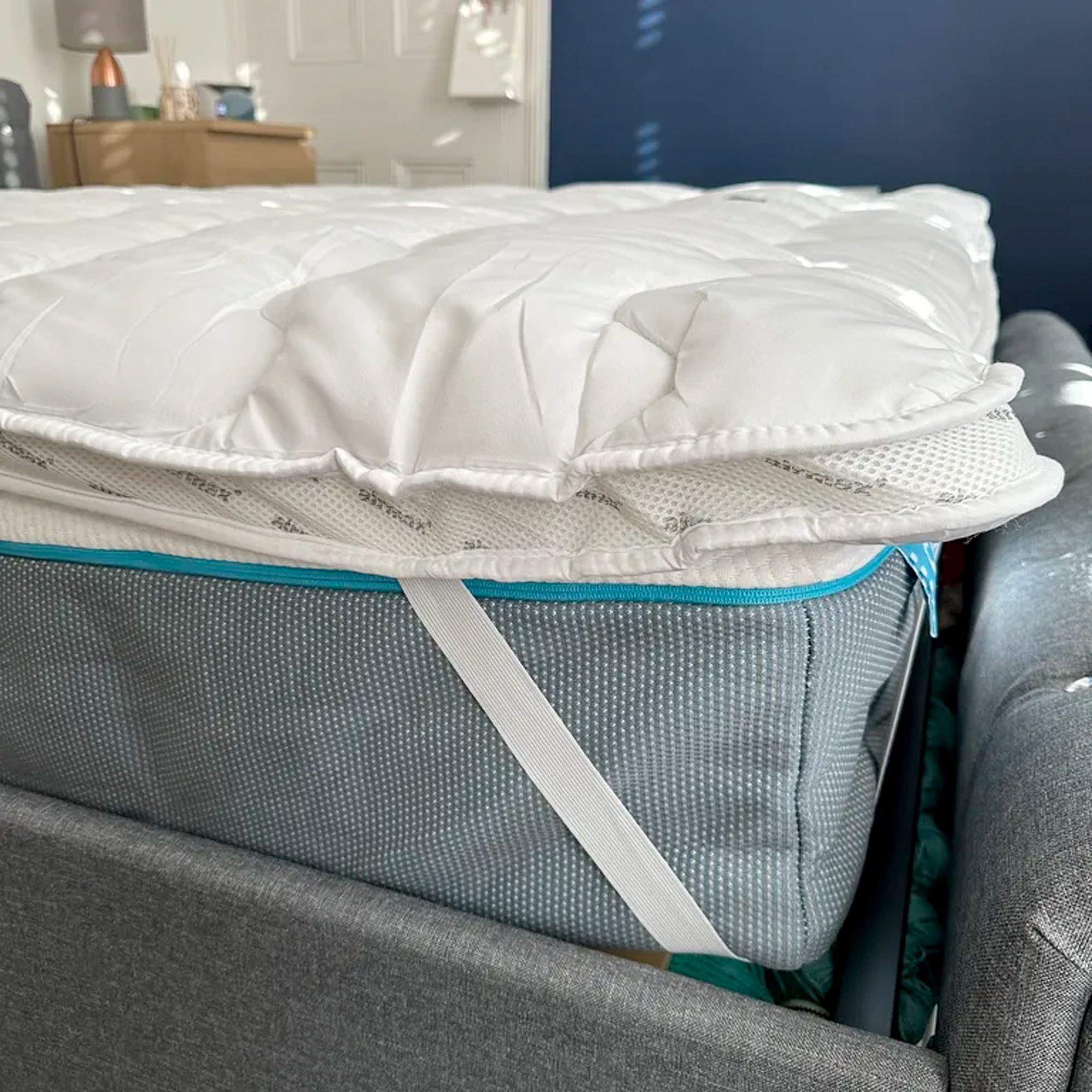One corner of the Silentnight Airmax mattress topper attached to a mattress via its elasticated corner straps