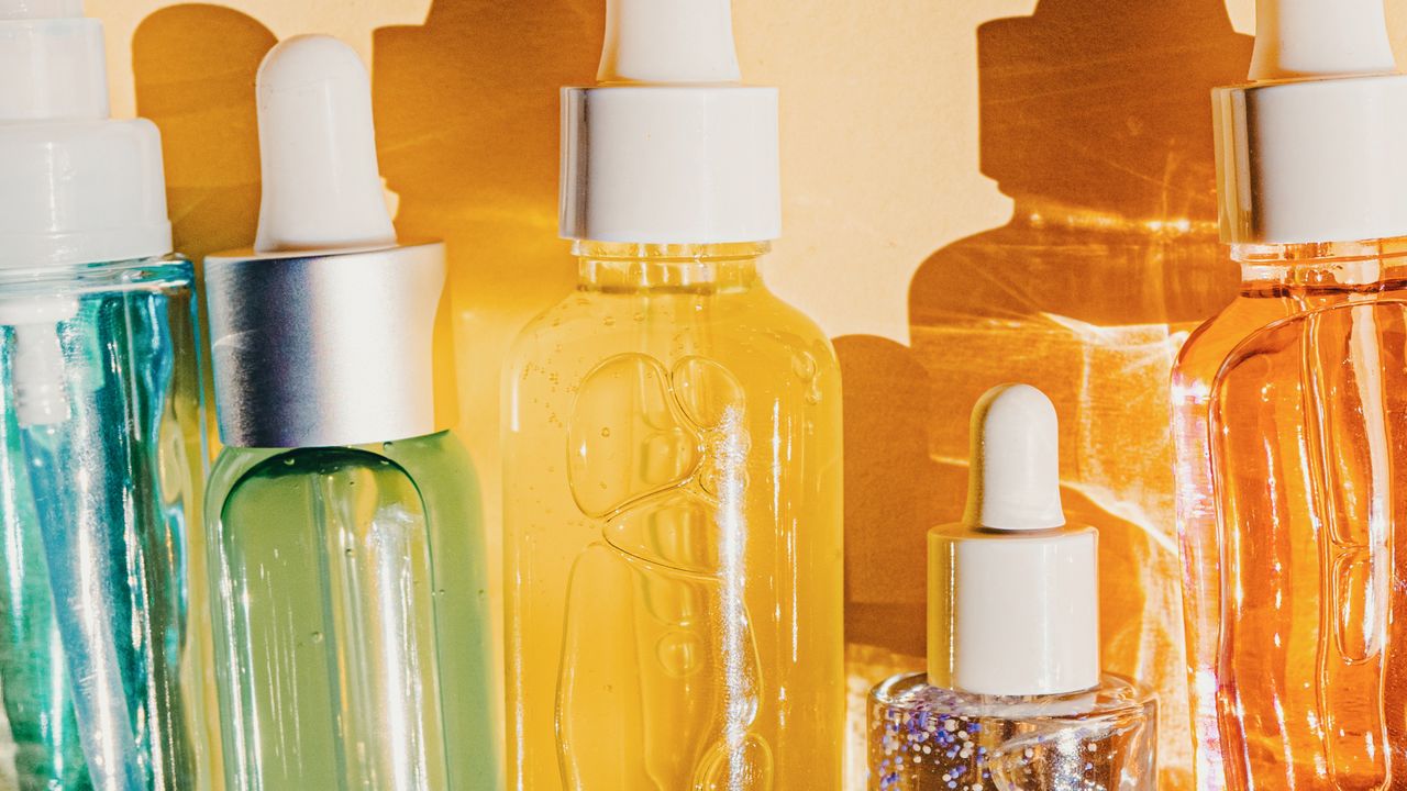 an editorial image of skincare products in front of a plain backdrop